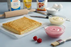 Ingrediënten voor het maken van een zelfgemaakte tompouce, inclusief bladerdeeg en glazuur.